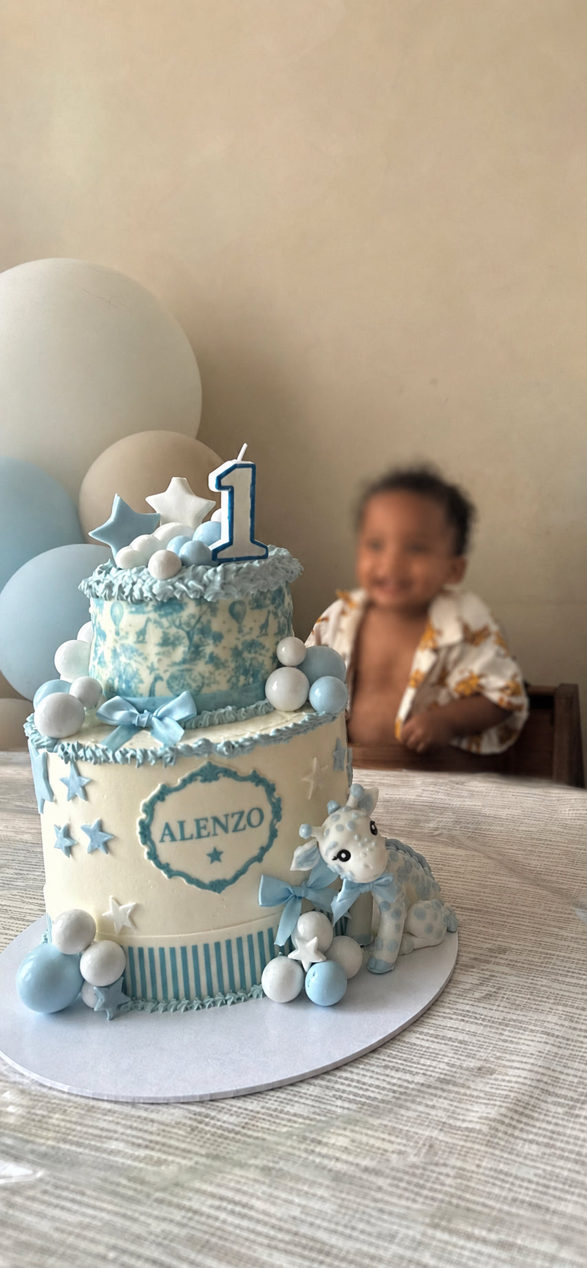 Luxe babyshower- en eerste verjaardagstaart van Cake Magic met teddybeer, blauwe en witte details, handgemaakte decoraties en botercrème, perfect voor een jongen zijn eerste verjaardag in Schiedam.