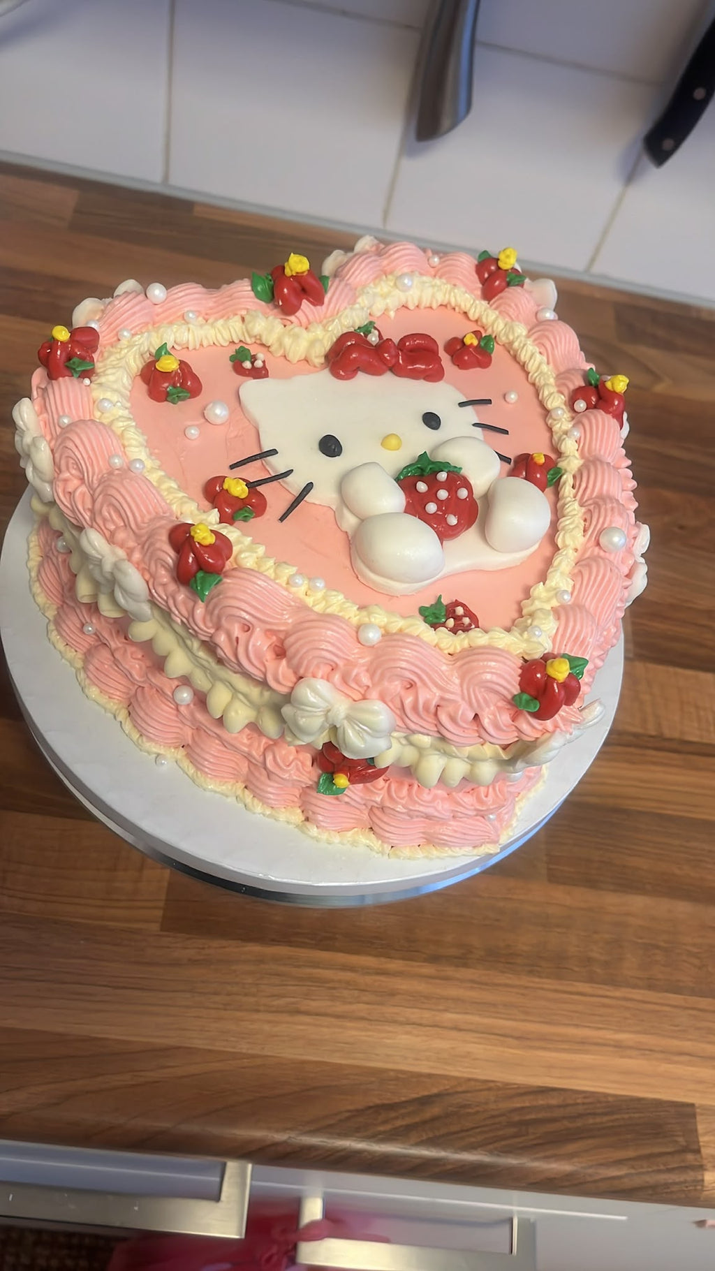 Hartvormige Hello Kitty taart van Cake Magic met roze botercrème, aardbeiendecoratie en 3D Hello Kitty, handgemaakt voor verjaardagen en speciale gelegenheden in Schiedam en omgeving Rotterdam.