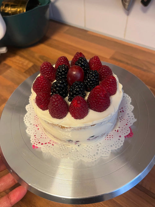Ronde suikervrije taart van Cake Magic met romige roomkaascrème, gezoet met pure maple syrup, zonder toegevoegde suikers en rijkelijk afgewerkt met verse frambozen, bramen en druiven. Ambachtelijke taart voor een bewust genietmoment in Schiedam en omgeving Rotterdam.