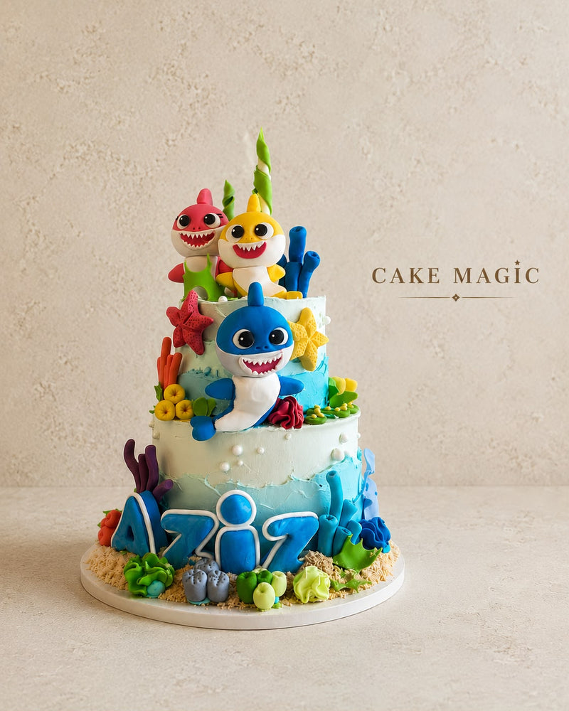 Baby Shark verjaardagstaart van Cake Magic met kleurrijke fondantfiguren, onderwaterthema, zeesterren, koraal en gepersonaliseerde naam Aziz. Luxe kindertaart voor een verjaardag in Schiedam en omgeving Rotterdam