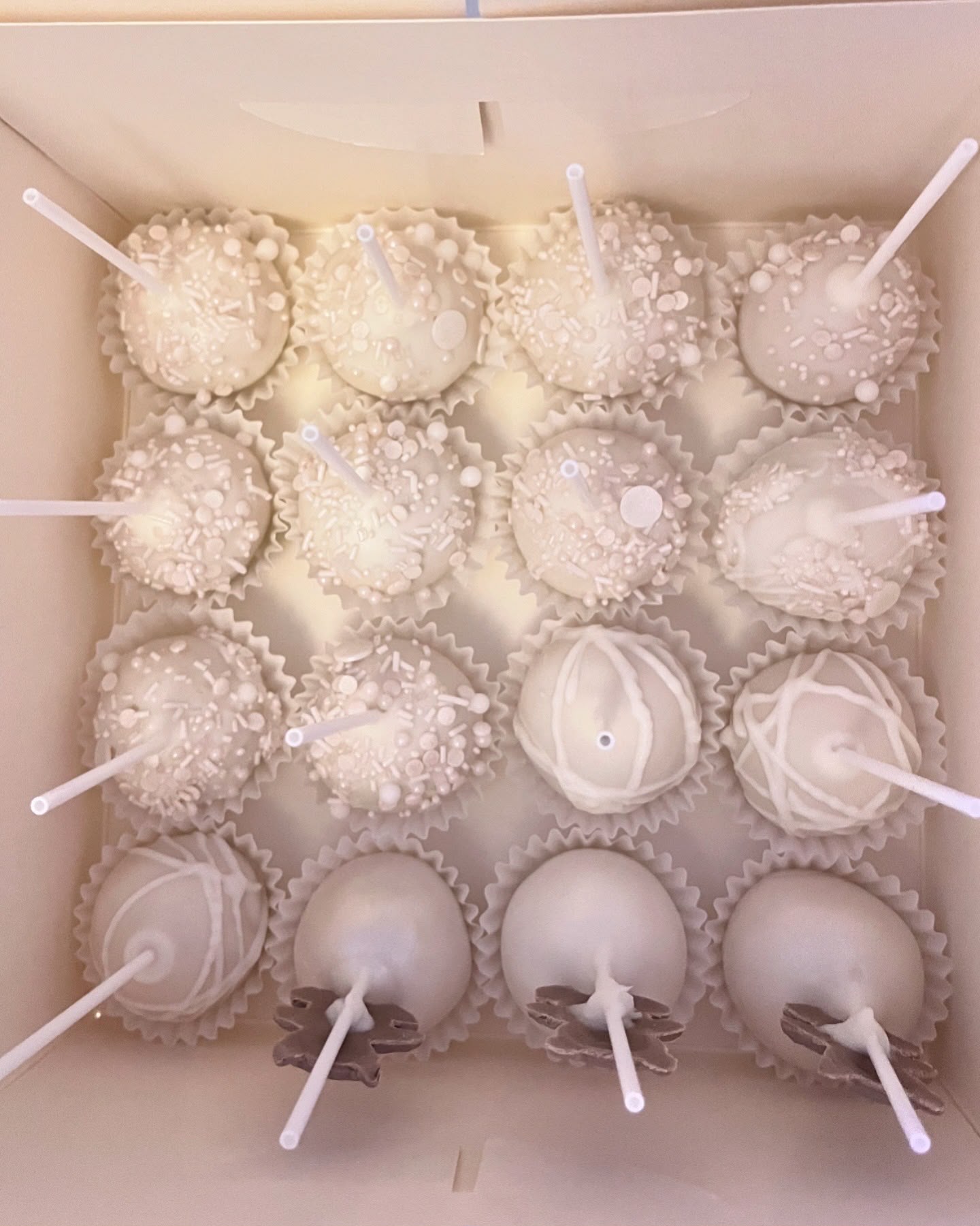 Luxe handgemaakte cake pops van Cake Magic, gedipt in witte chocolade en afgewerkt met elegante witte sprinkels en decoraties. Perfect voor bruiloften, babyshowers, verjaardagen, doopfeesten en andere feestelijke gelegenheden in Schiedam en omgeving.